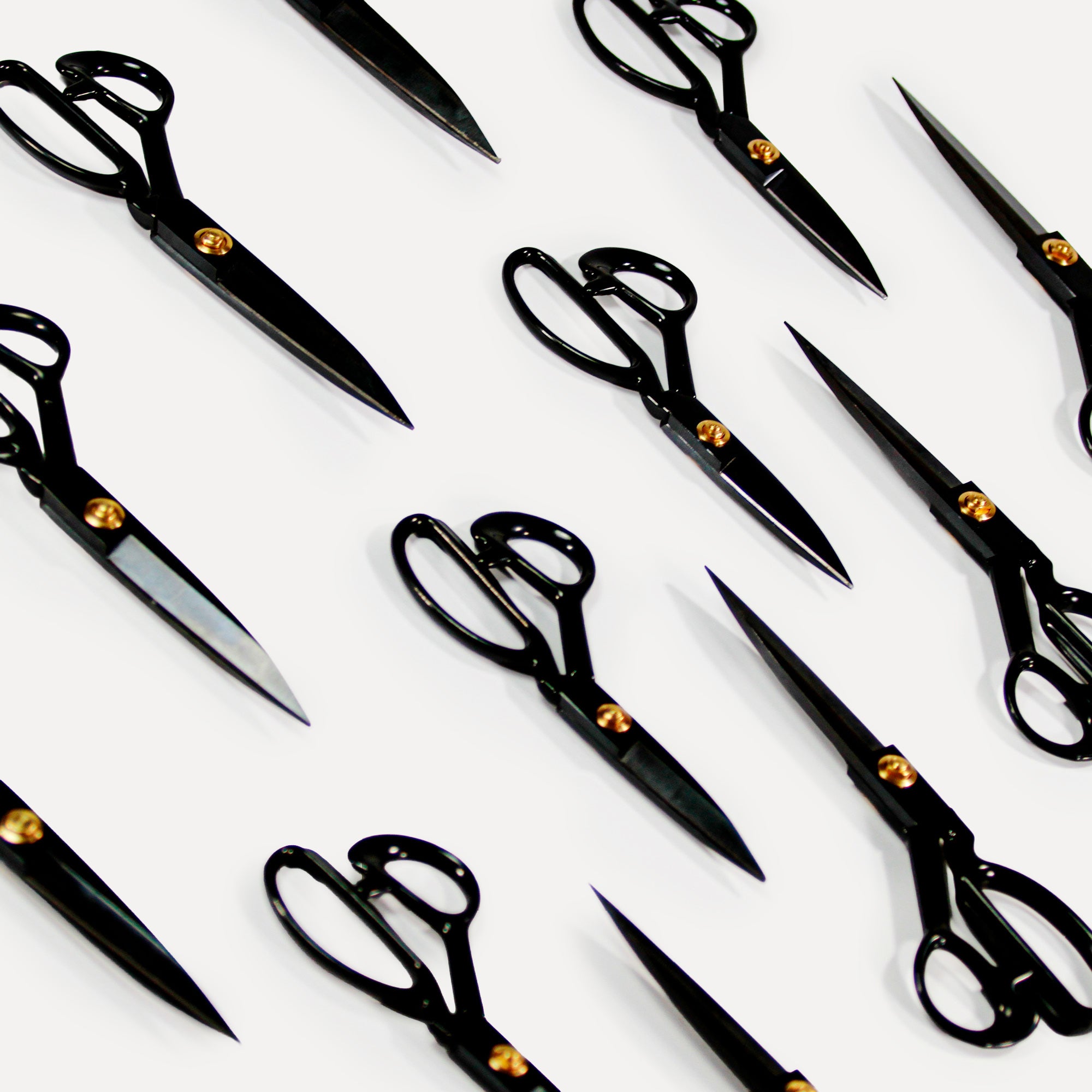 Multiple black textile scissors arranged diagonally on a white background – ideal for precise fabric, yarn, and tufting cuts.